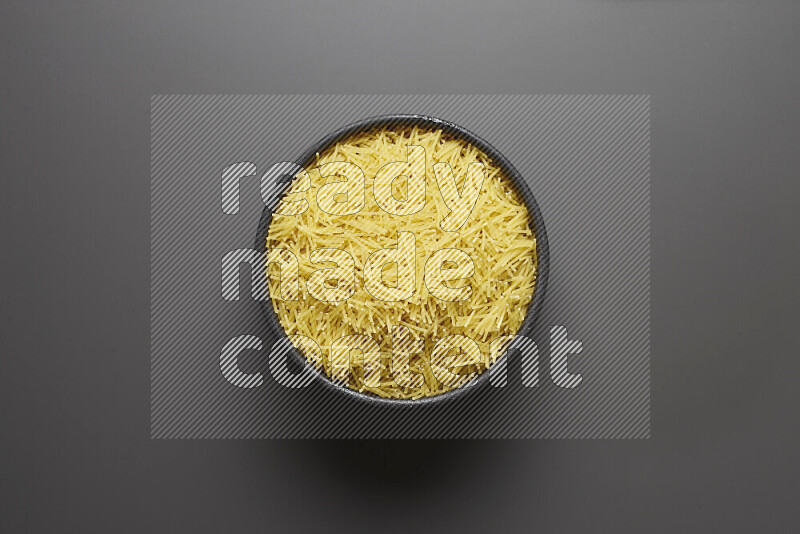 Vermicelli pasta in a pottery bowl on grey background