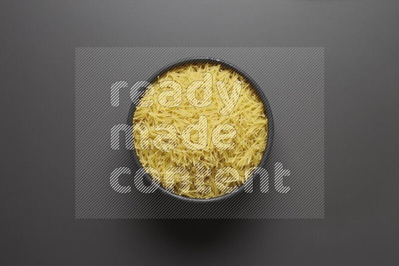 Vermicelli pasta in a pottery bowl on grey background