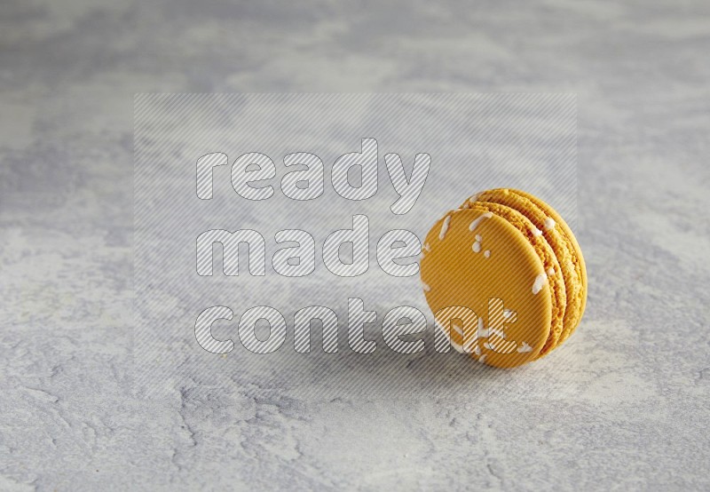 45º Shot of Yellow Piña Colada macaron on white  marble background