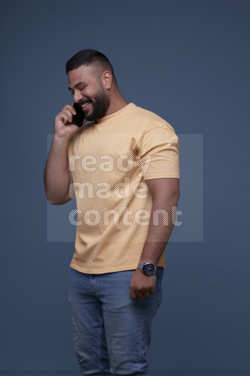 A man Calling on Blue Background wearing Orange T-shirt