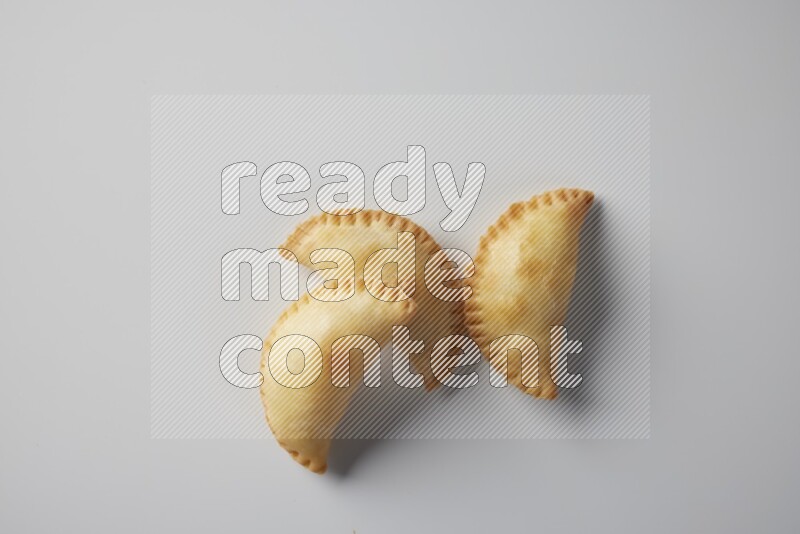 Three fried sambosa from a top angle on a white background