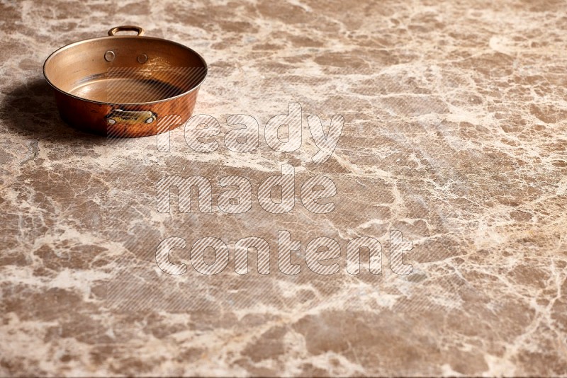 Small Copper Pan on Beige Marble Flooring, 45 degrees