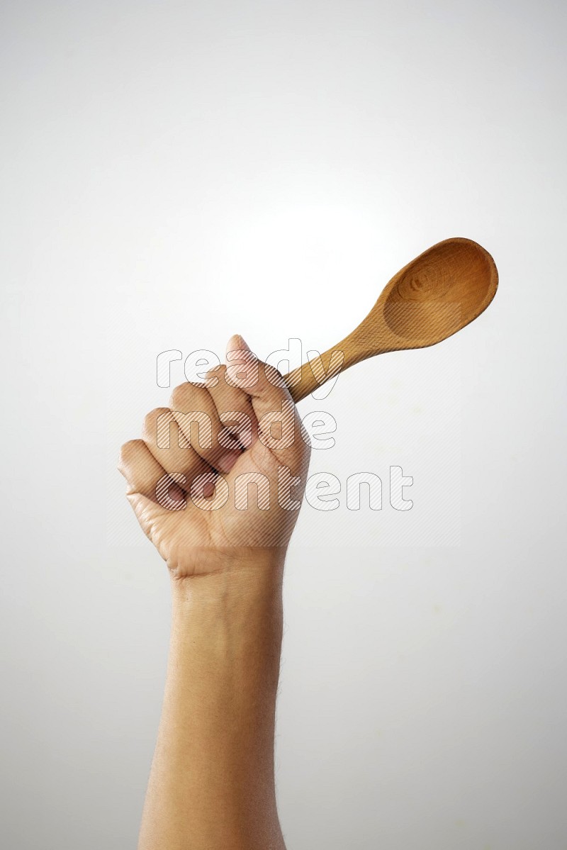 Male Hand Holding Wooden spoon on white background