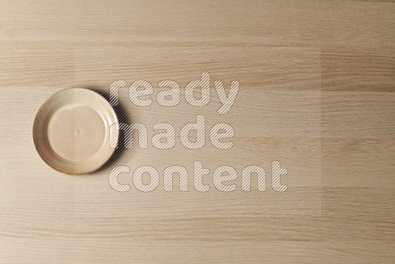 Top View Shot Of A Beige Pottery Plate on Oak Wooden Flooring