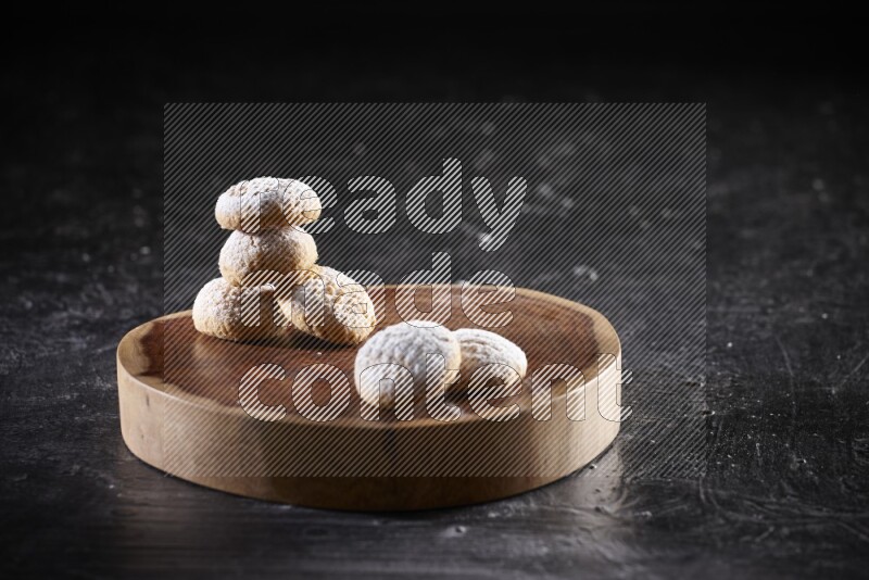 Kahk on a serving plate on a black background