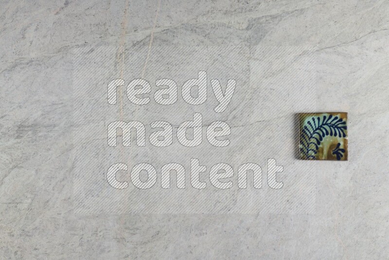 A decorative pottery coaster on grey marble background