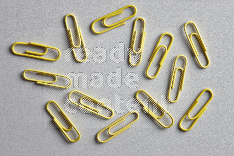 Yellow paperclips isolated on a grey background