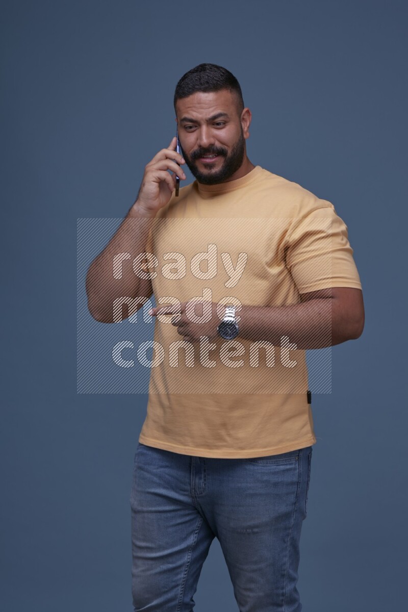 A man Calling on Blue Background wearing Orange T-shirt