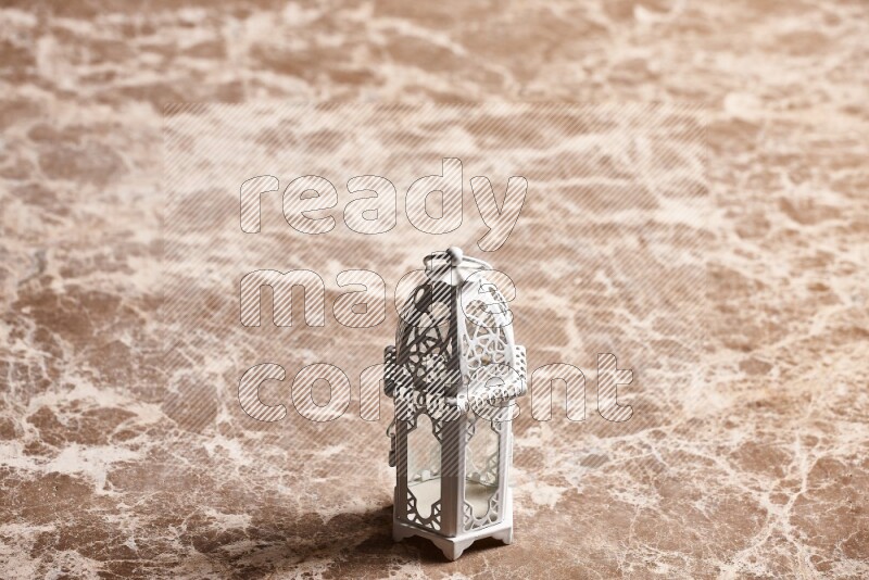 فانوس للشموع على خلفية رخام بيج