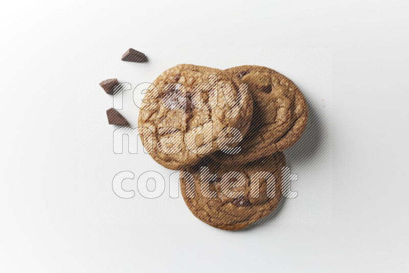 Chocolate chips cookies with chocolate beside it on a white background