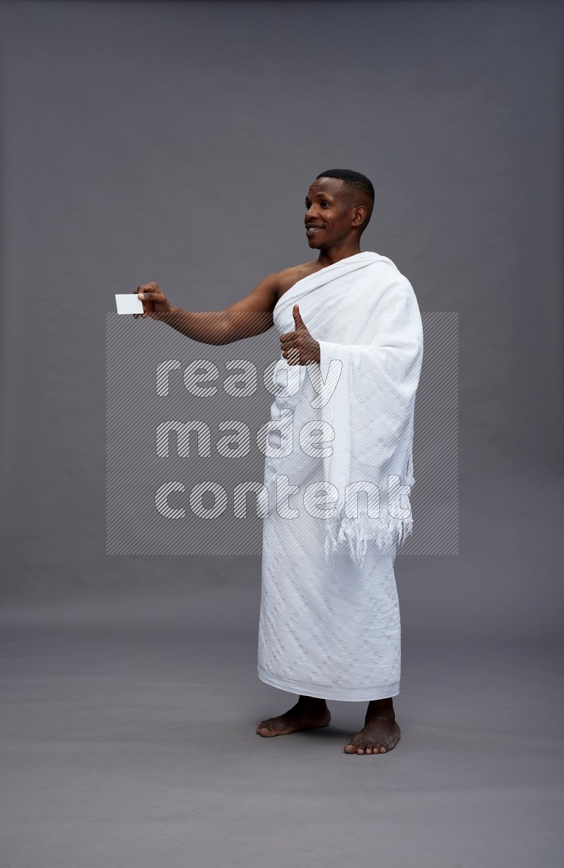 A man wearing Ehram Standing holding ATM card on gray background