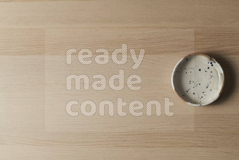 وعاء فخاري متعدد الألوان على خلفية خشبية فاتحة