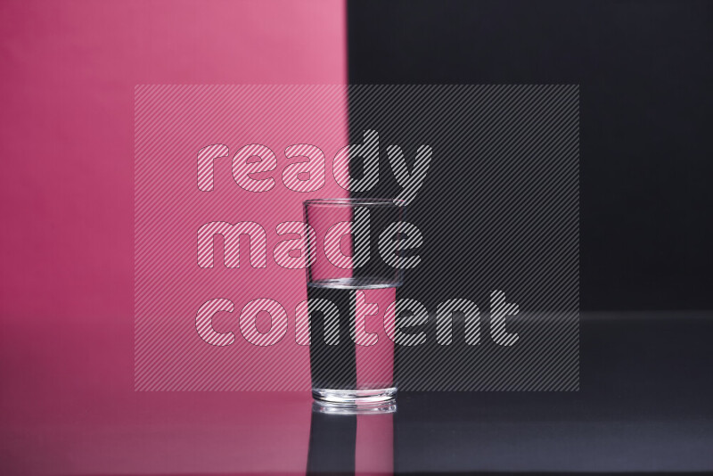 The image features a clear glassware filled with water, set against pink and black background