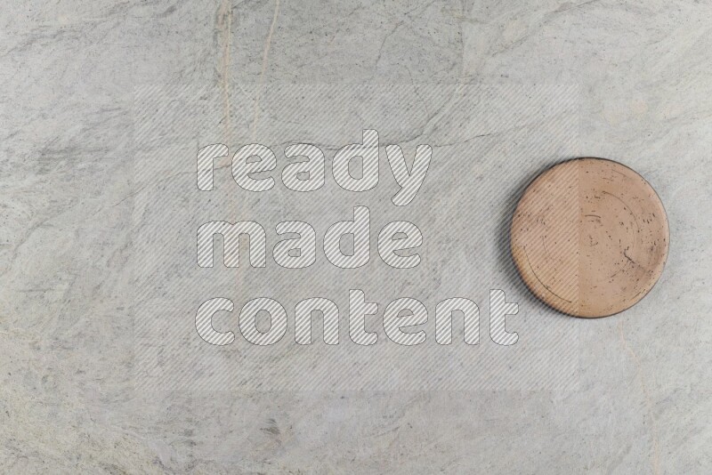 A pottery coaster on grey marble background
