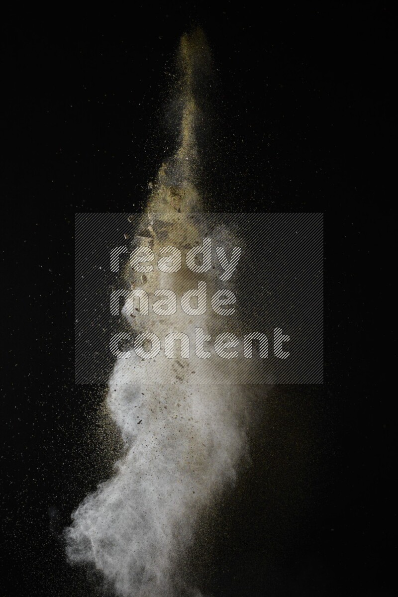 A side view of brown powder explosion on black background
