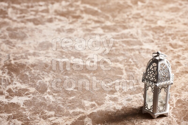 A candle lantern on beige marble background