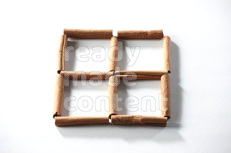 4 empty squares of cinnamon sticks on white flooring