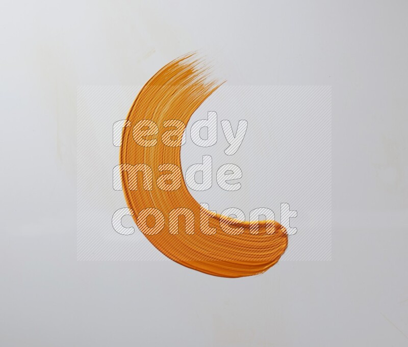 An orange half circular painting brush stroke on white background