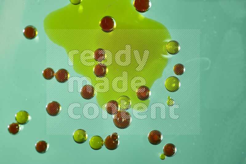 Close-ups of abstract green and red watercolor drops on oil Surface on green background