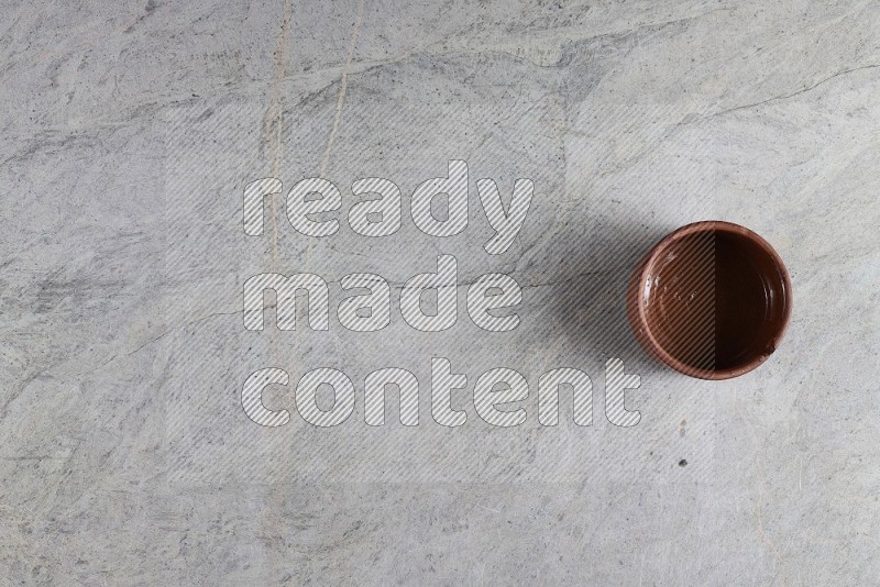 Top View Shot Of A Brown Pottery Bowl On Grey Marble Flooring