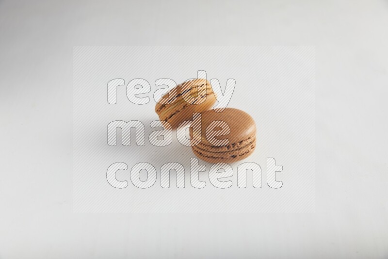 45º Shot of of two assorted Brown Irish Cream, and Brown Coffee macarons  on white background