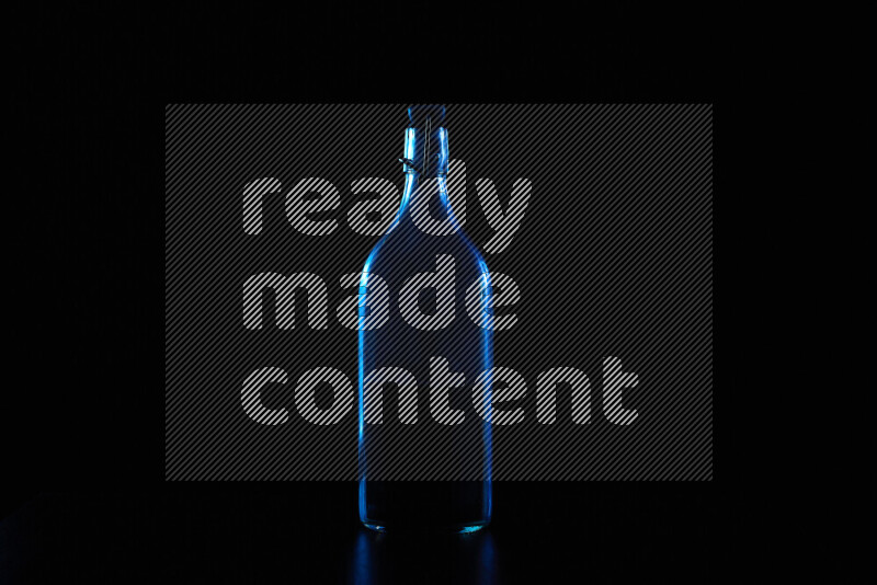 Water bottle with colored rim light against black background