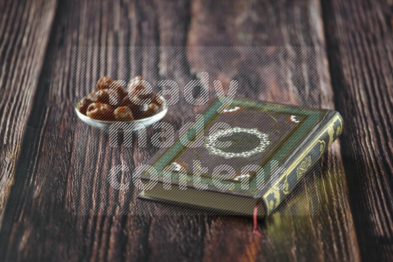 Quran with dates, prayer beads and different drinks all placed on wooden background