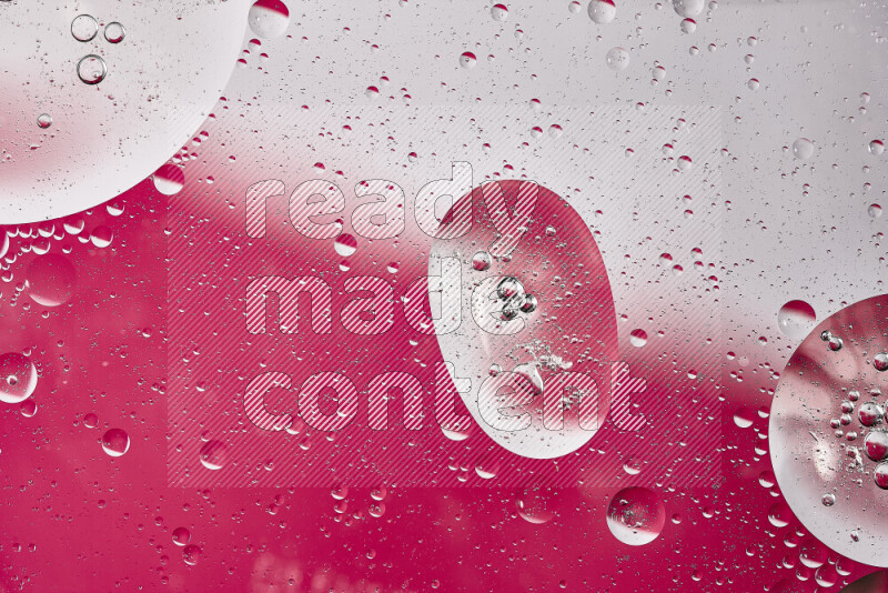 Close-ups of abstract oil bubbles on water surface in shades of white and pink