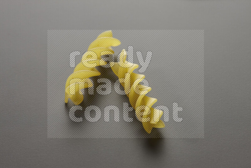 Fusilli pasta on grey background