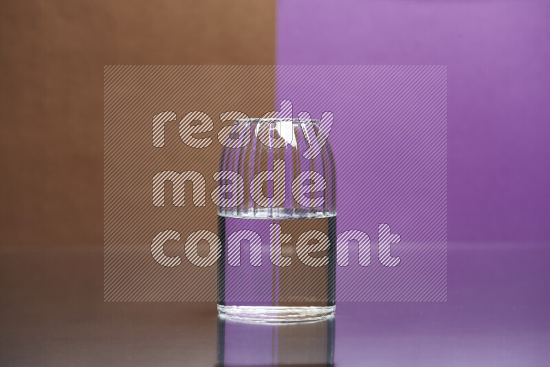 The image features a clear glassware filled with water, set against brown and purple background