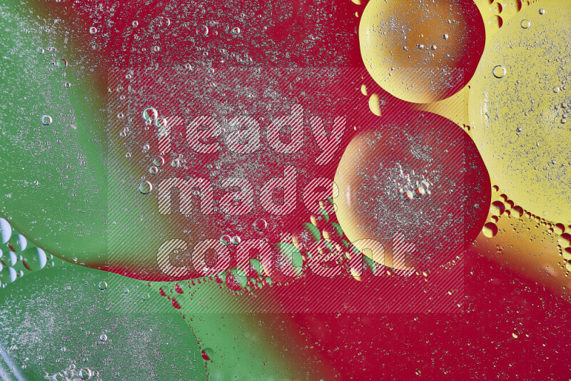 لقطات مقربة لفقاعات من الزيت على سطح الماء باللون الأصفر والأخضر والأحمر