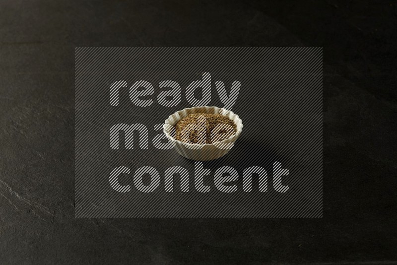 white ceramic round sauce bowl filled with herbs on grey textured countertop