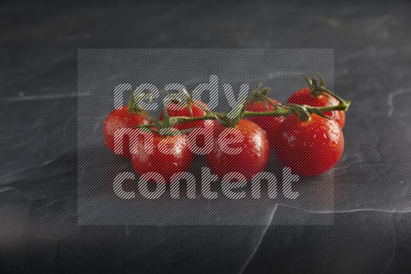 Red cherry tomato vein on a textured black slate background 45 degree