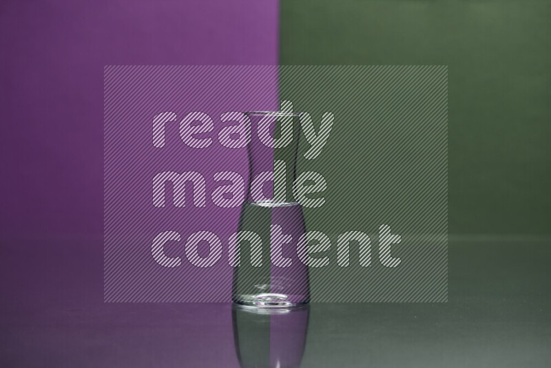 The image features a clear glassware filled with water, set against purple and dark green background