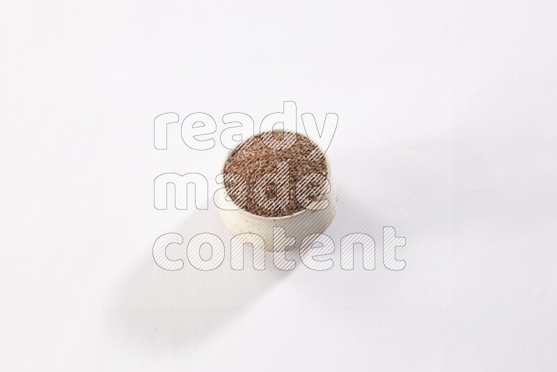 وعاء بيج فخاري ممتلئ بحبوب بذر الكتان علي خلفية بيضاء