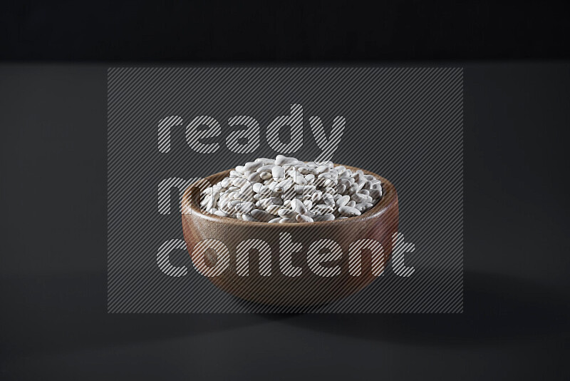 Snacks in a wooden bowl on grey background