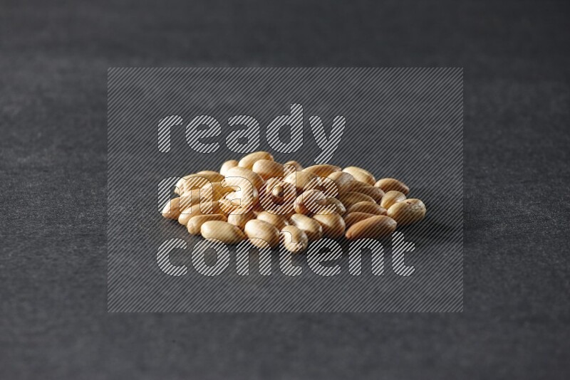 مجموعة من حبات الفول السوداني المقشرعلي خلفية سوداء