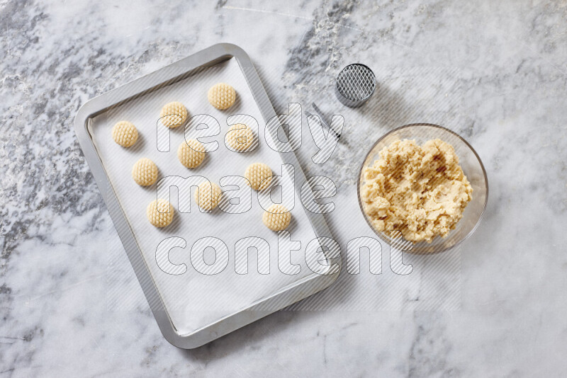 Kahk step by step with its ingredients ghee, sugar, flour, sesame, yeast, water and kahk flavor on grey marble background