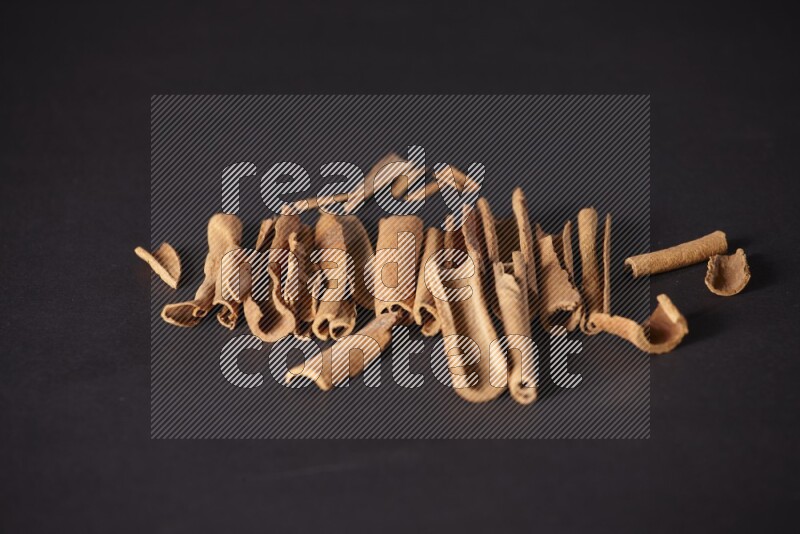 Cracked cinnamon sticks on a black background