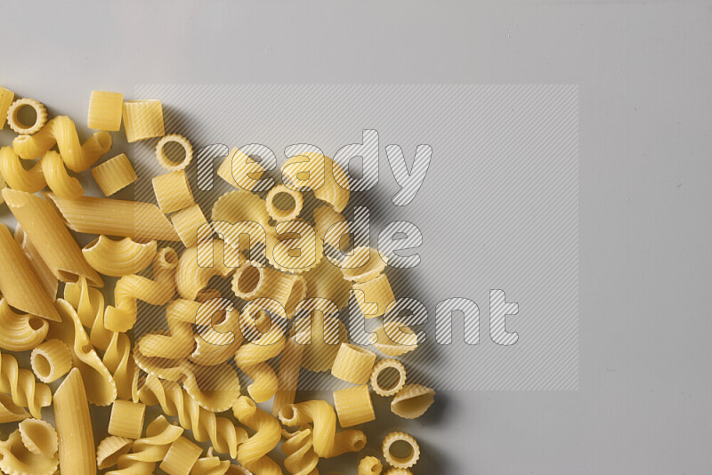 Different pasta types on light blue background