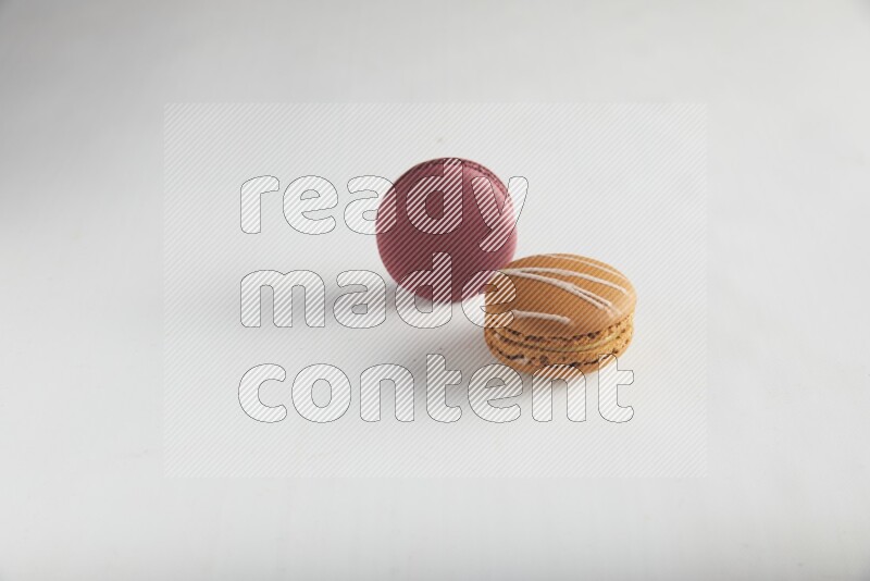45º Shot of of two assorted Brown Irish Cream, and Red Cherry macarons on white background