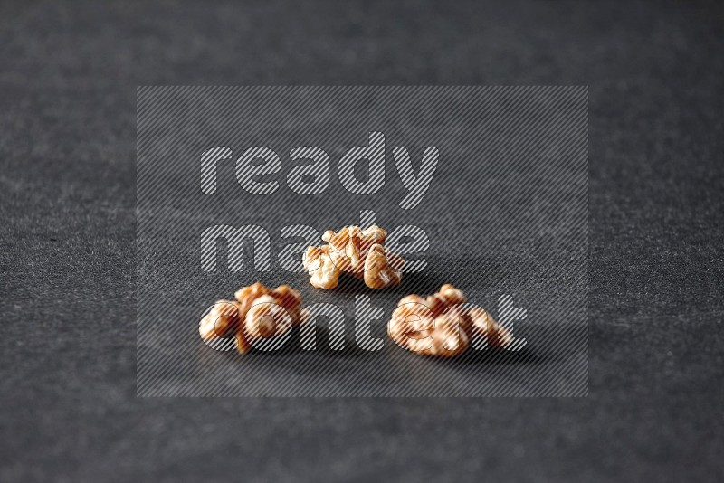 3 walnuts on a black background in different angles