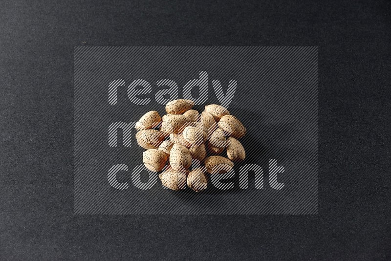 A bunch of almonds on a black background in different angles