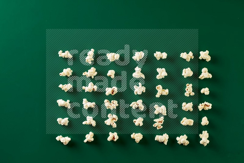 Popcorn flakes on a green background in a top view shot