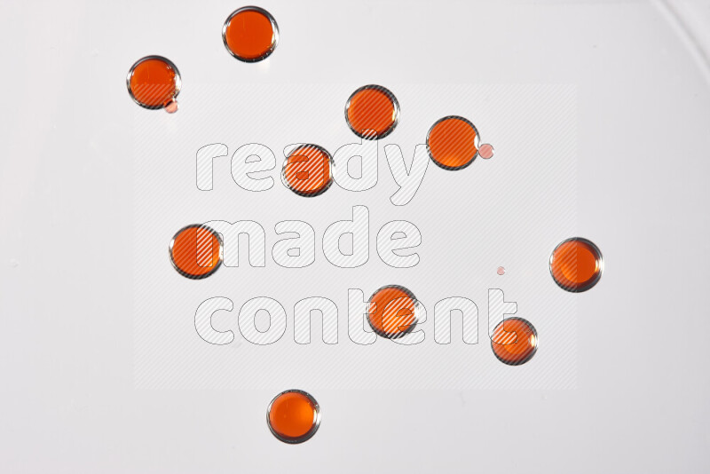 لقطات مقربة لقطرات ألوان مائية حمراء على سطح الزيت على خلفية بيضاء