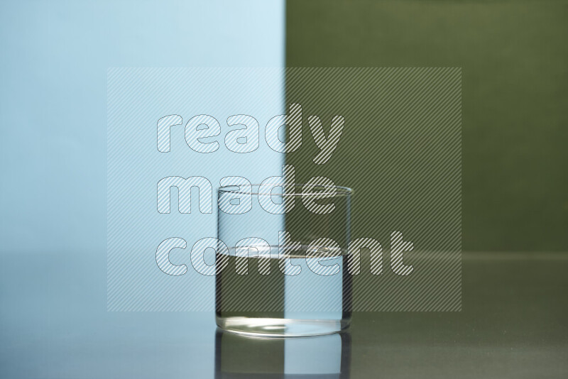 The image features a clear glassware filled with water, set against light blue and dark green background