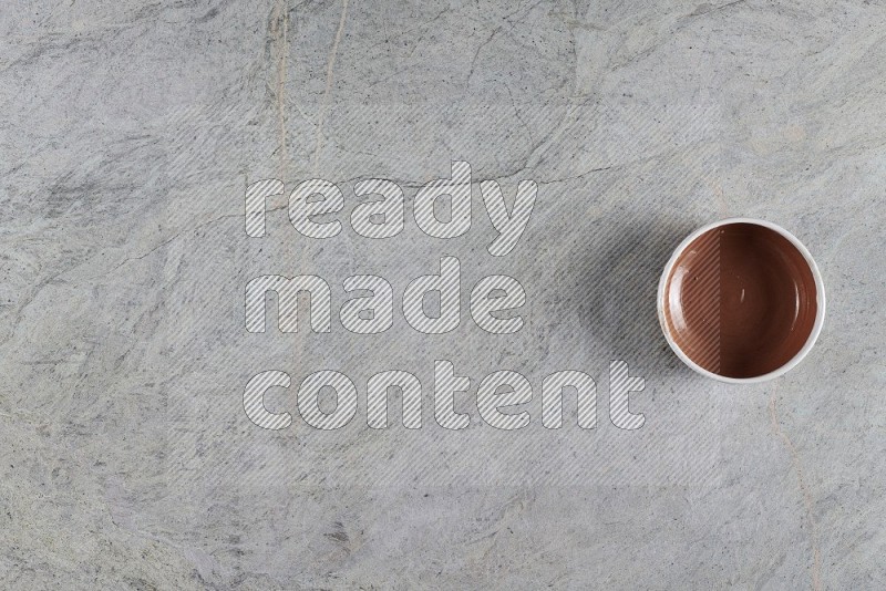 Top View Shot Of A Brown Pottery Bowl On Grey Marble Flooring