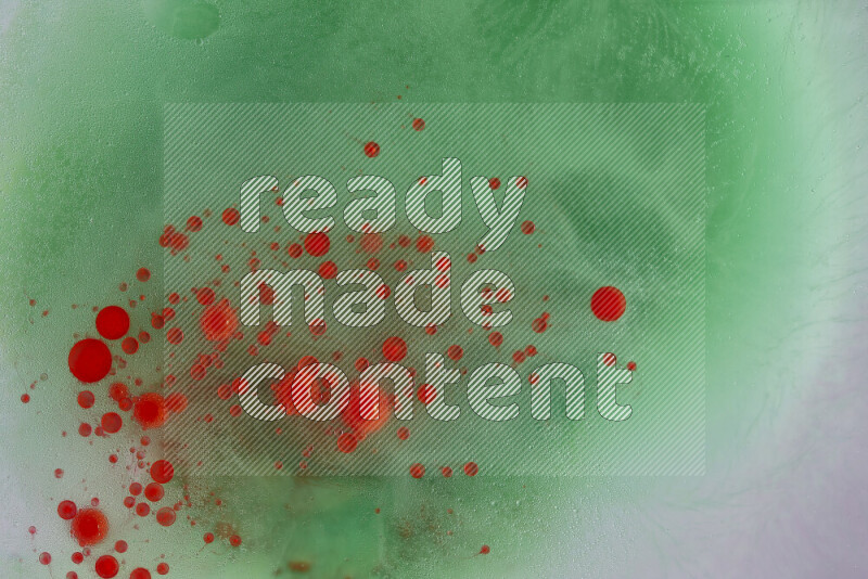 The image captures a dramatic splatter of red paint over a green backdrop