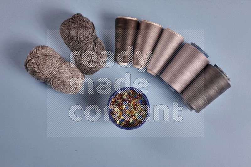 Grey sewing supplies on blue background