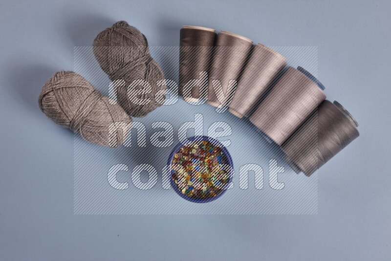 مجموعة من أدوات الخياطة والتفصيل رمادية اللون على خلفية زرقاء